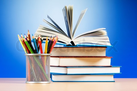 A book on a desk with a pencil holder next to it. A book on a desk with a pencil holder next to it.